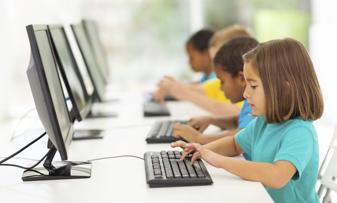 Imagen de recurso de varios niños frente a un ordenador