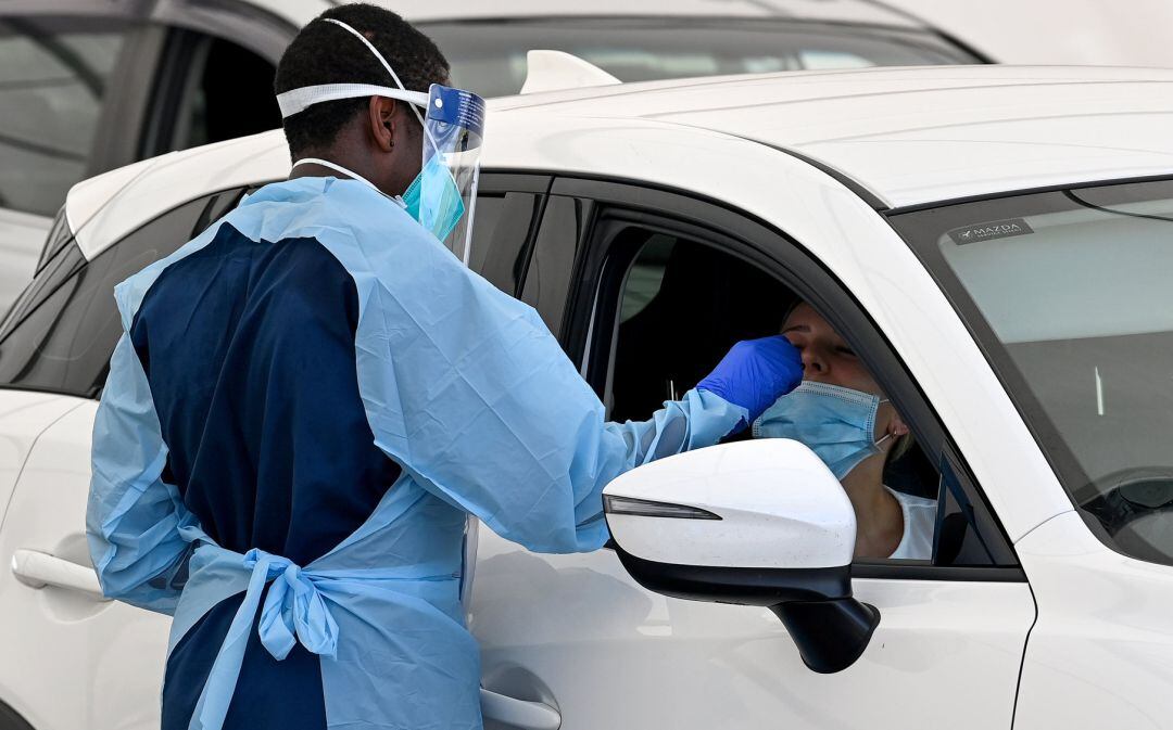 Healthcare workers administer COVID-19 tests at the St Vincent’s Hospital drive-through testing clinic at Bondi Beach in Sydney, Sunday, December 19, 2021. NSW is recording more COVID-19 cases than ever  