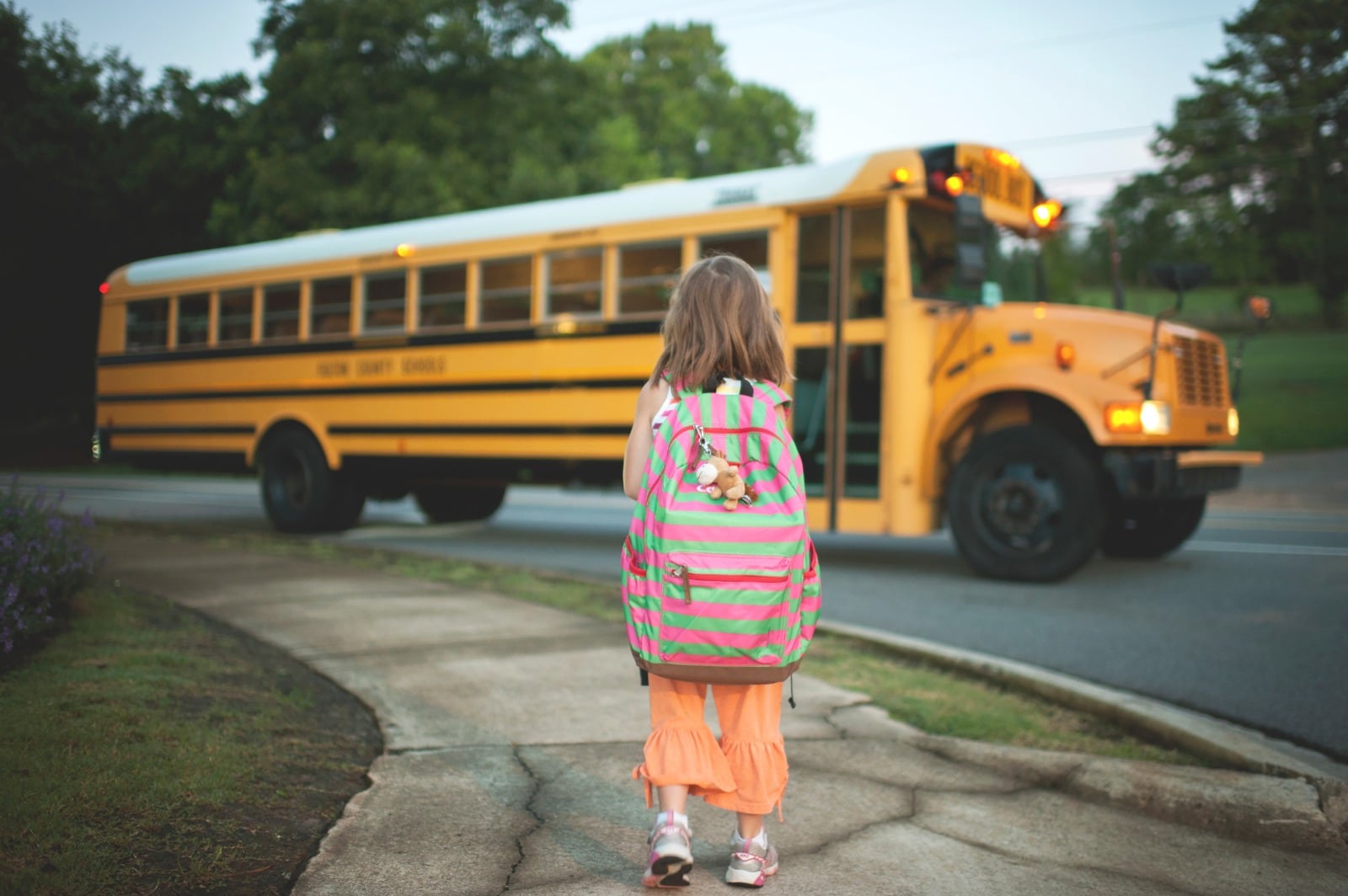 Foto de archivo de una niña frente a un autobús escolar en Estados Unidos.