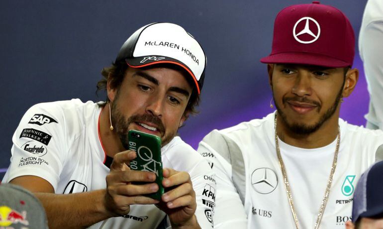 Alonso enseña su móvil a Lewis Hamilton