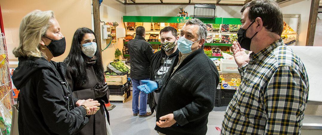 Representantes del PP coruñés hablando con placeros de Adormideras