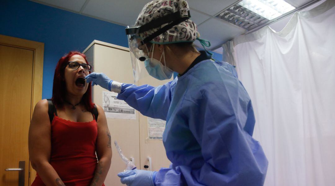 Una trabajadora sanitaria realiza una prueba PCR a una de las personas que ha acudido durante la jornada de hoy a realizarse un test al dispositivo instalado en el Centro de Especialidades El Arroyo, en Fuenlabrada, Madrid, (España), a 27 de agosto de 202