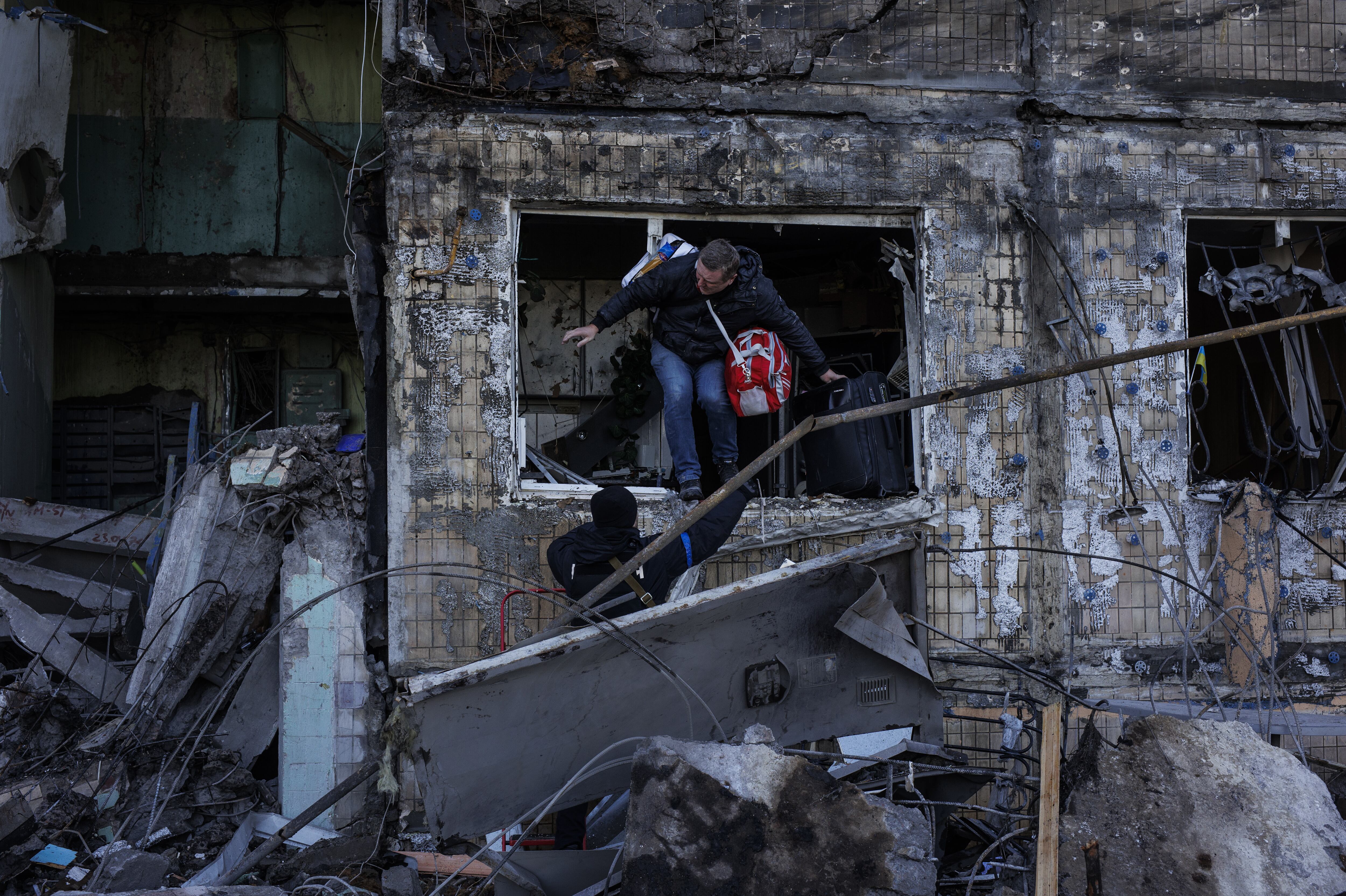 Un hombre sale de un edificio de apartamentos reducido a ruinas en Kiev, después de recoger los restos de sus pertenencias