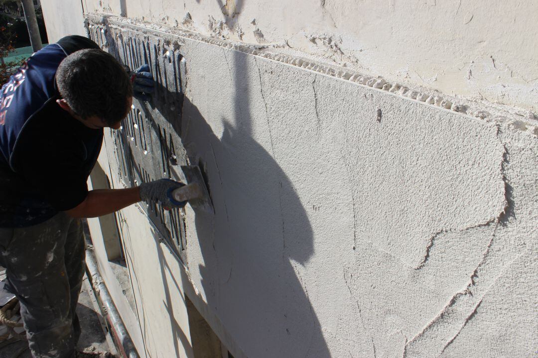 Trabajos de un operario para cubrir una placa con simbología franquista en un edificio de Irun. 