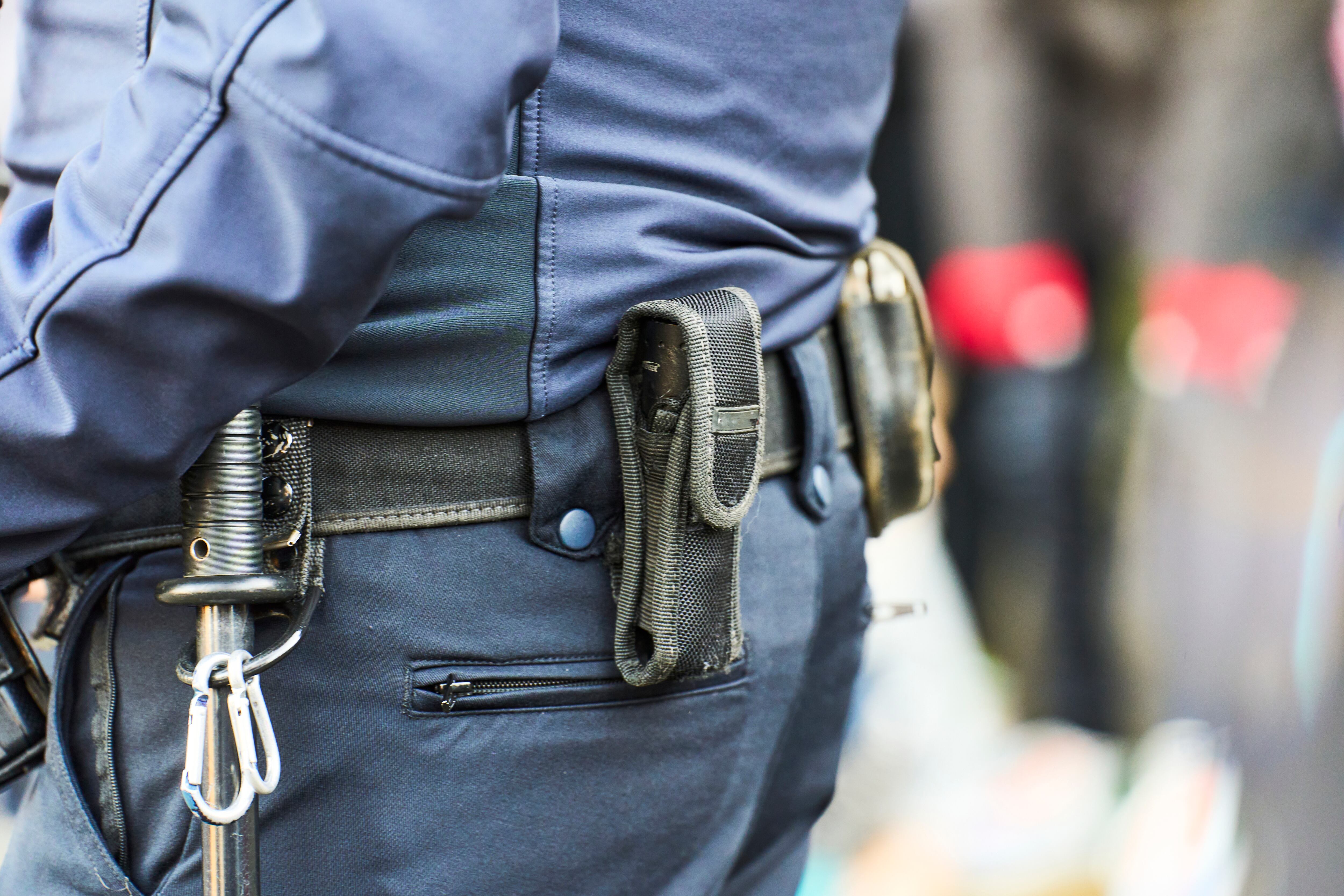 Close-up side view of the belt of an armed police officer standing on the city streets