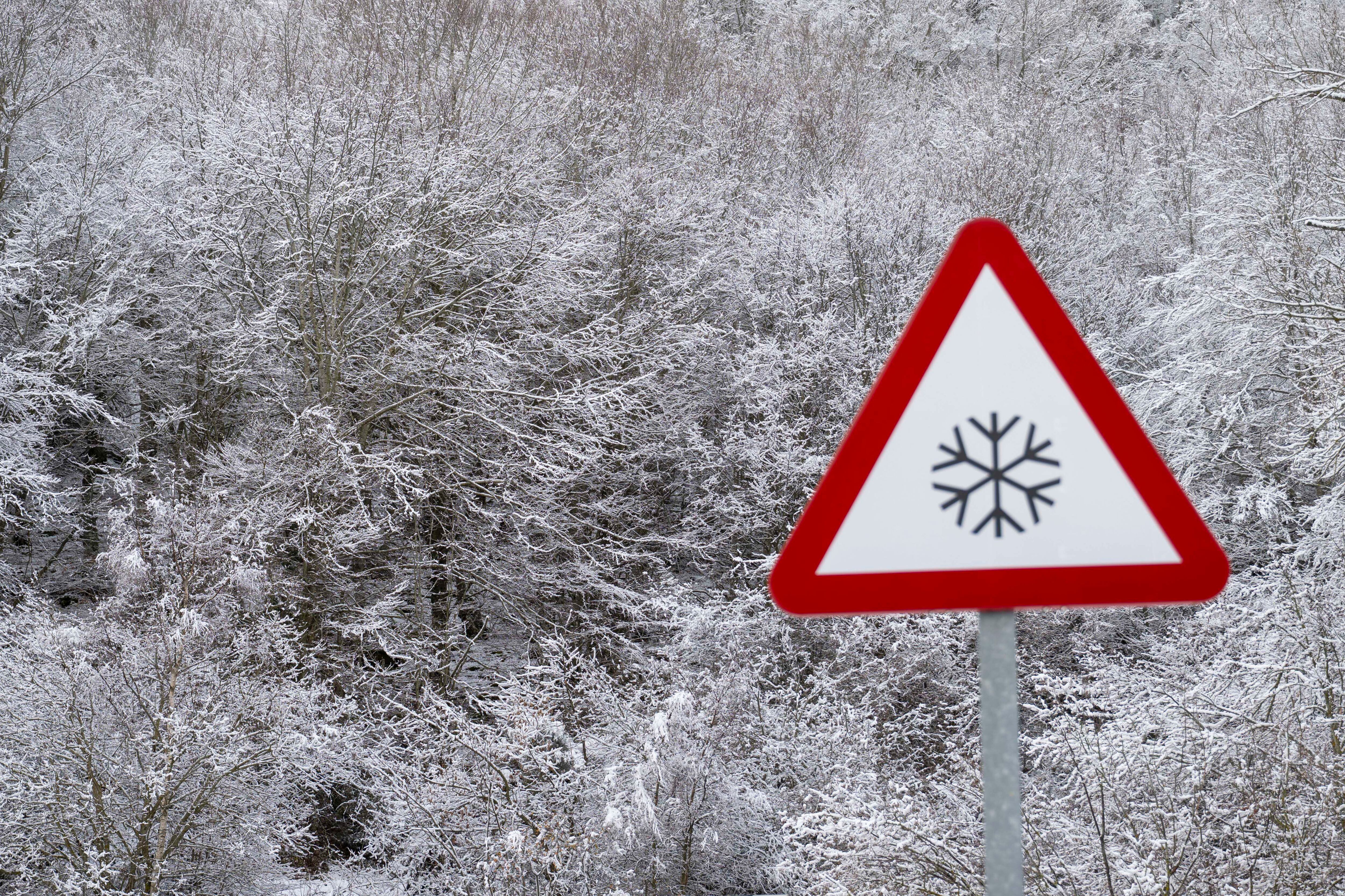 Vista de una señal con el fondo nevado este lunes en la localidad cántabra de Brañavieja. 