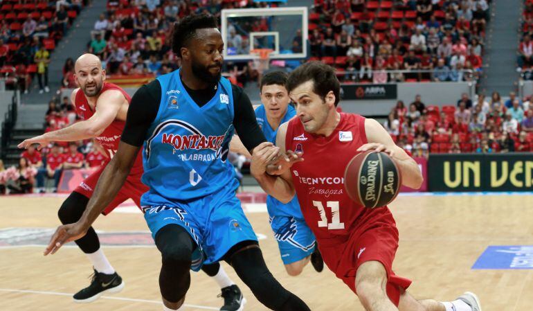 El base del Tecnyconta Zaragoza, Tomás Bellas (d), protege el balón ante la presencia del pívot británico del Montakit Fuenlabrada, Gabriel Olaseni, durante el parido correspondiente a la jornada 33 de Liga Endesa.