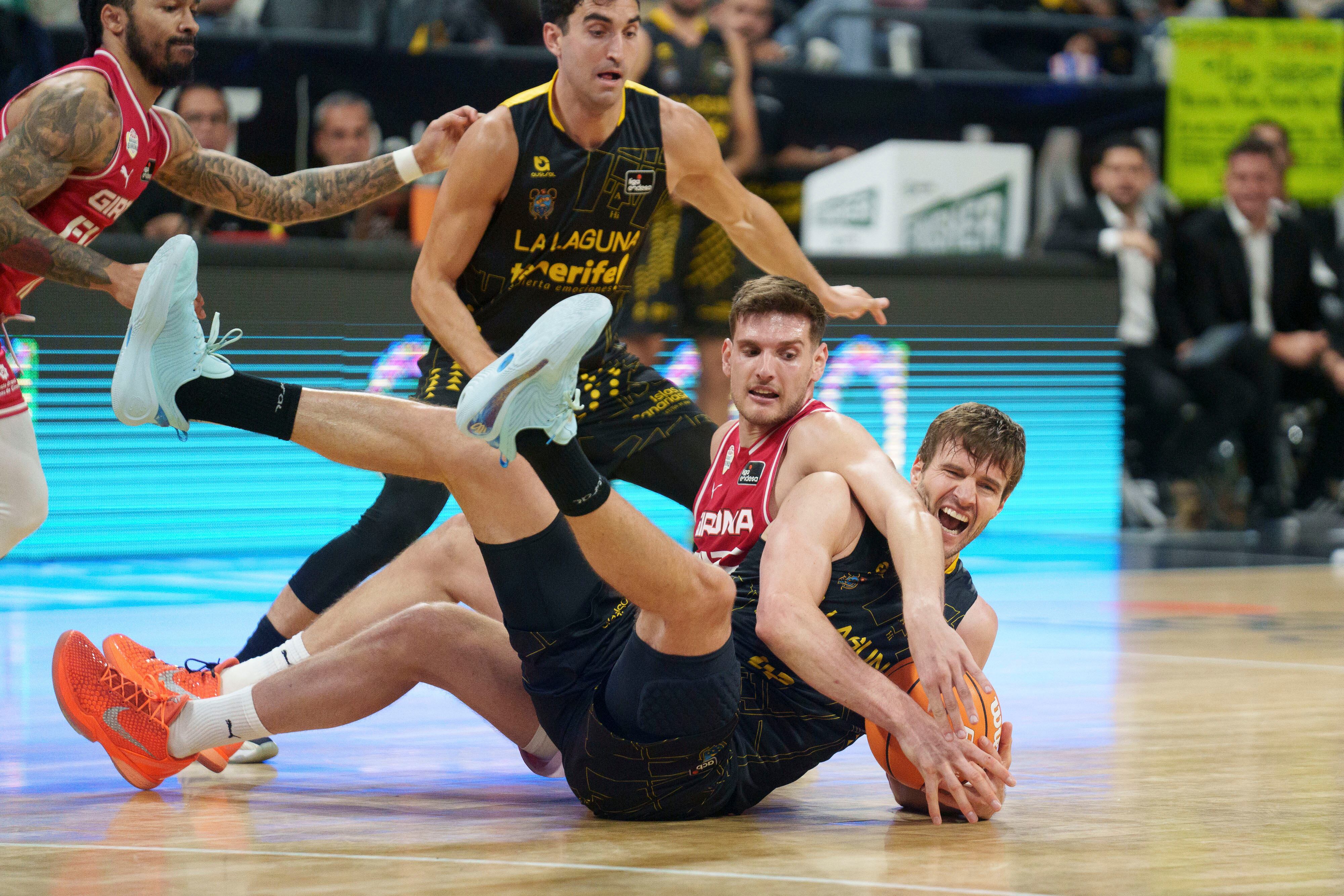 LA LAGUNA (TENERIFE), 11/04/2026.- El ala-pívot de La Laguna Tenerife, Aaron Doornekamp (d), pugna por un balón con Sergi Martínez, del Girona Basquet, durante el partido correspondiente a Liga Endesa que se celebra este sábado en el Pabellón Santiago Martín de La Laguna (Tenerife) entre el La Laguna Tenerife y el Girona Basquet. EFE/Ramón de la Rocha