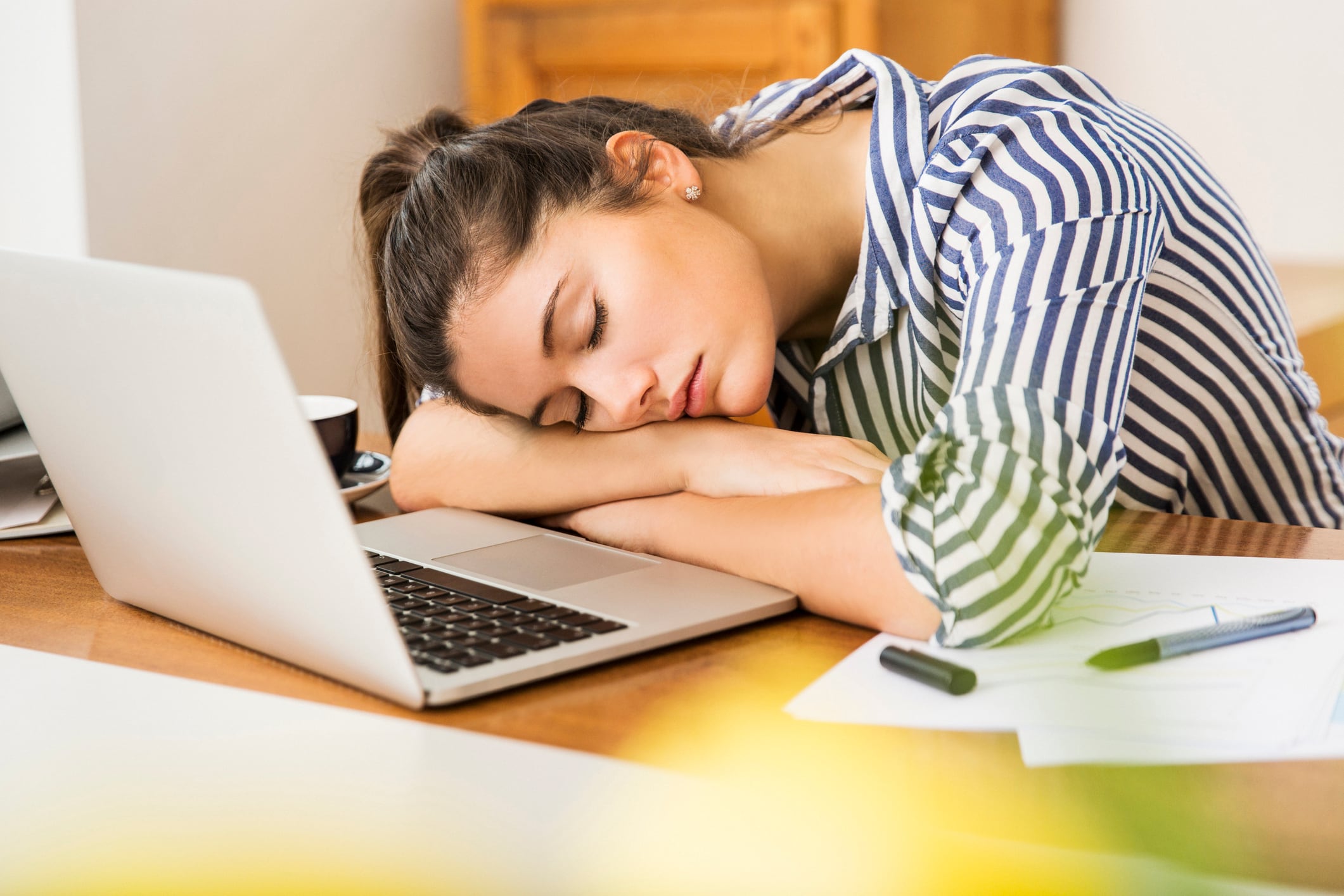 Una joven durmiendo sobre su portátil.