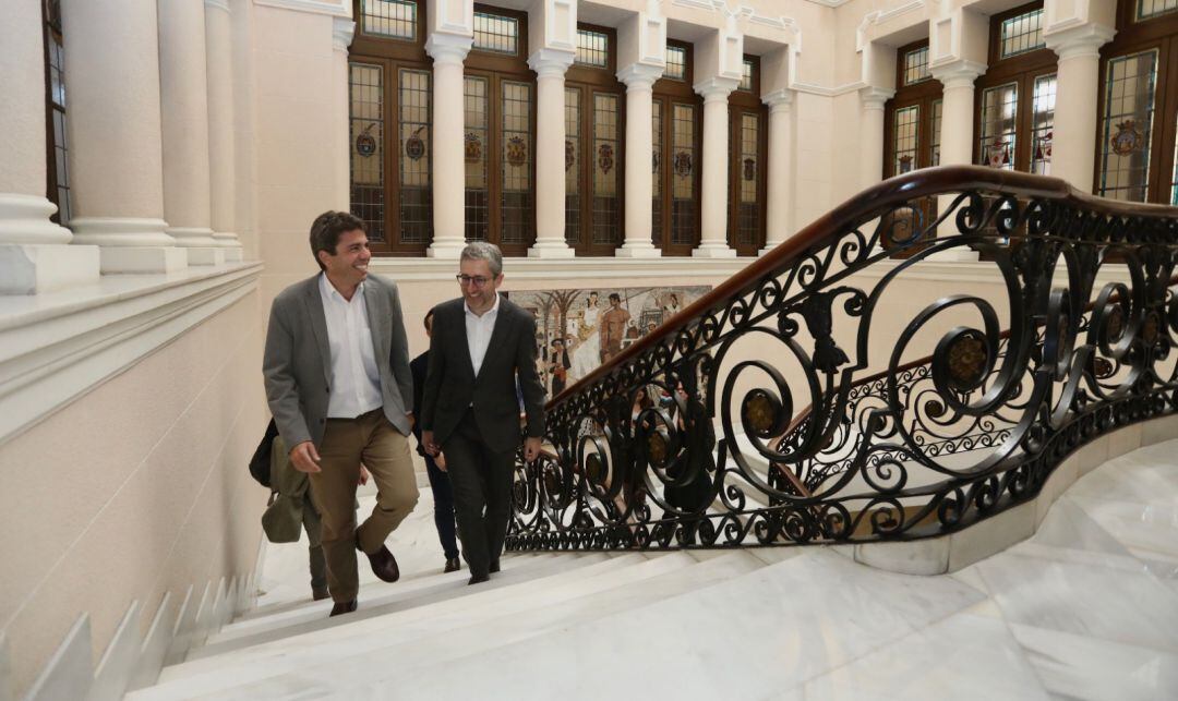 El presidente de la Diputación, Carlos Mazón, (i), sube las escaleras del Palacio Provincial, acompañado por el conseller de Política Territorial, Arcadi España (d).