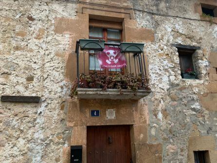 Una casa antigua con una bandera de Zaldibar Argitu en su balcón