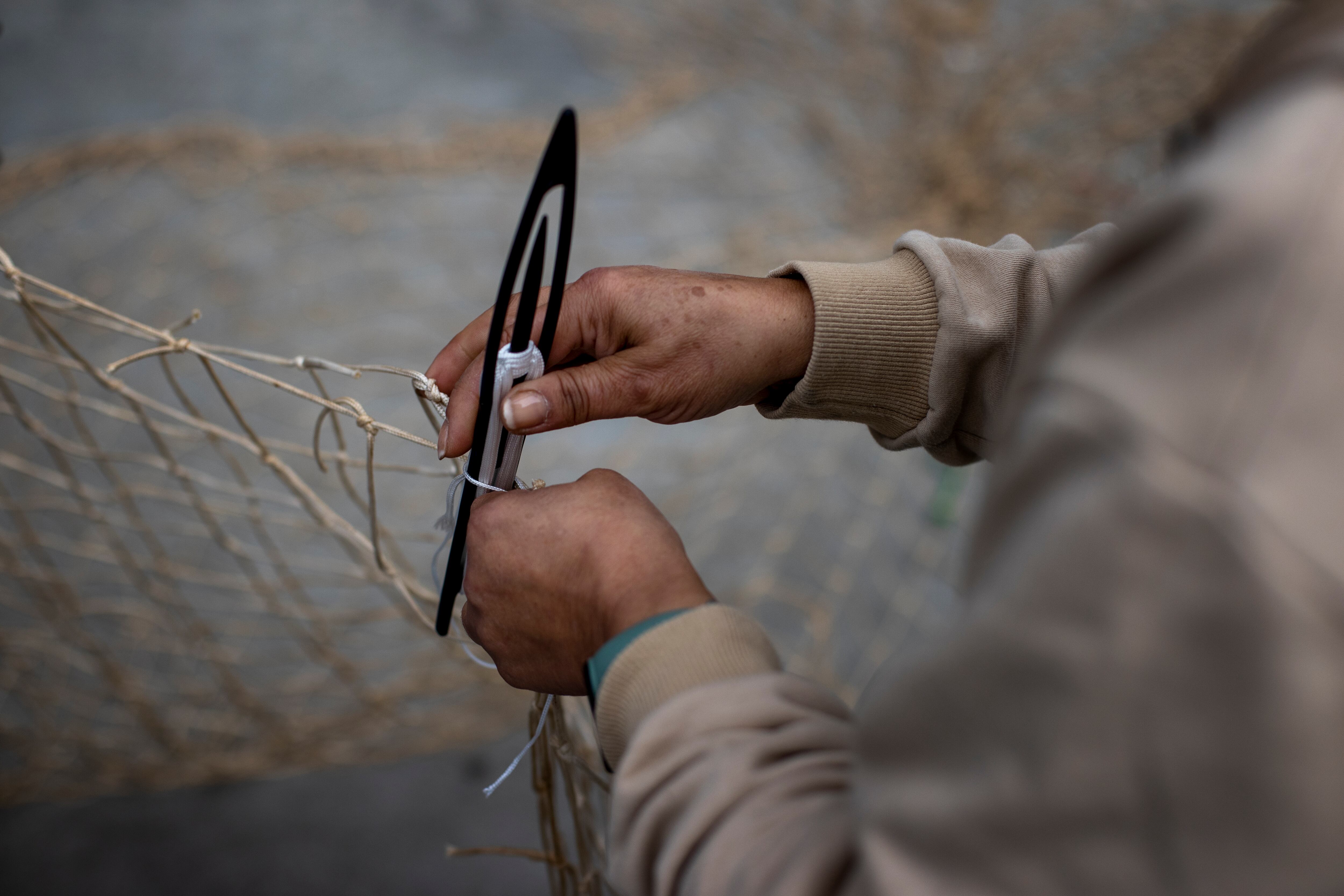 Imagen de archivo de un pescador arreglando sus redes