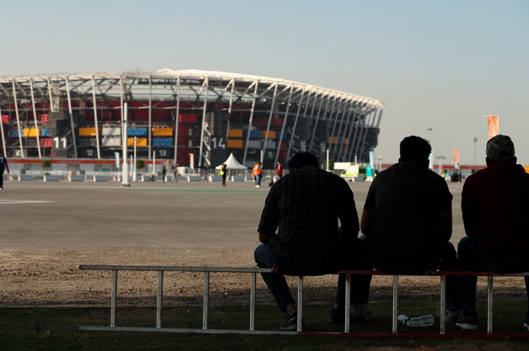 Tres aficionados fuera de uno de los estadios para Catar 2022