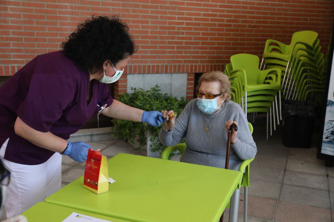 Una gerocultora ayuda a levantar a un residente 