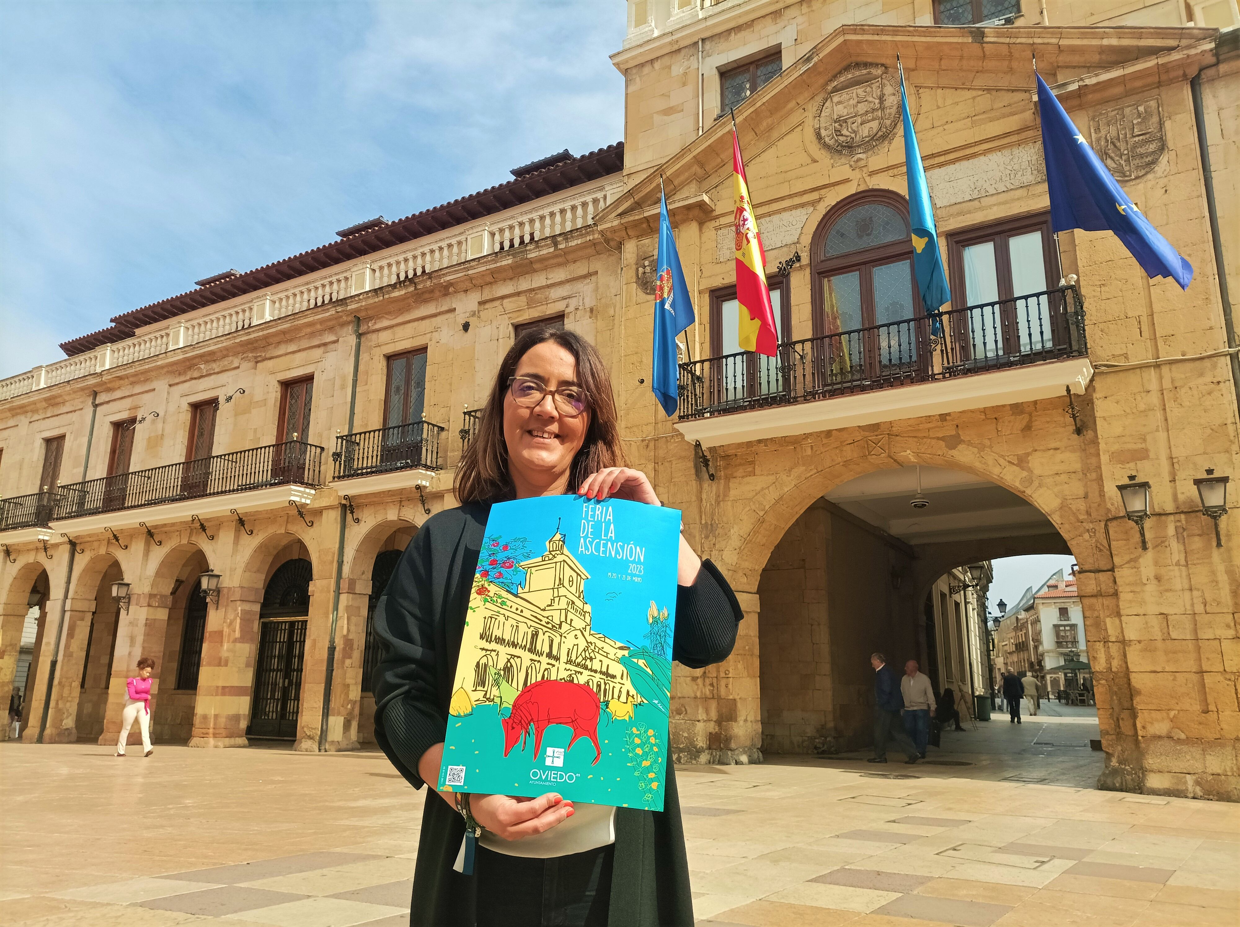 Covadonga Díaz, concejala de Festejos de Oviedo, con el cartel de Toño Velasco para La Ascensión