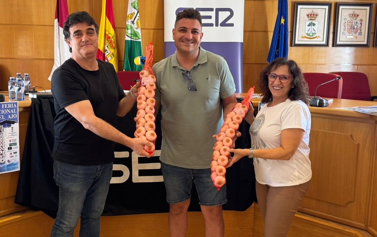 El concejal de Las Pedroñeras, Vicente Antonio Hergueta (centro) entrega sendas ristras de ajos a Paco Auñón (izq.), director y presentador del programa Hoy por Hoy Cuenca, y a Laura Benita (dch.), directora del Departamento Comercial de SER Cuenca.