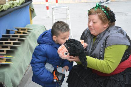 Un niño besa el peluche en honor a Gabriel el &quot;Pescaito&quot; en el Mercado Goyesco de Elda