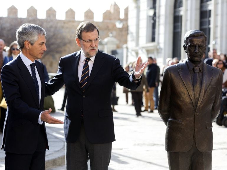 El candidato del PP a la Presidencia del Gobierno, Mariano Rajoy, junto a Adolfo Suárez Illana, hijo del expresidente del Gobierno Alfonso Suárez, ante el monumento en su memoria, en Ávila, tras un acto de campaña.