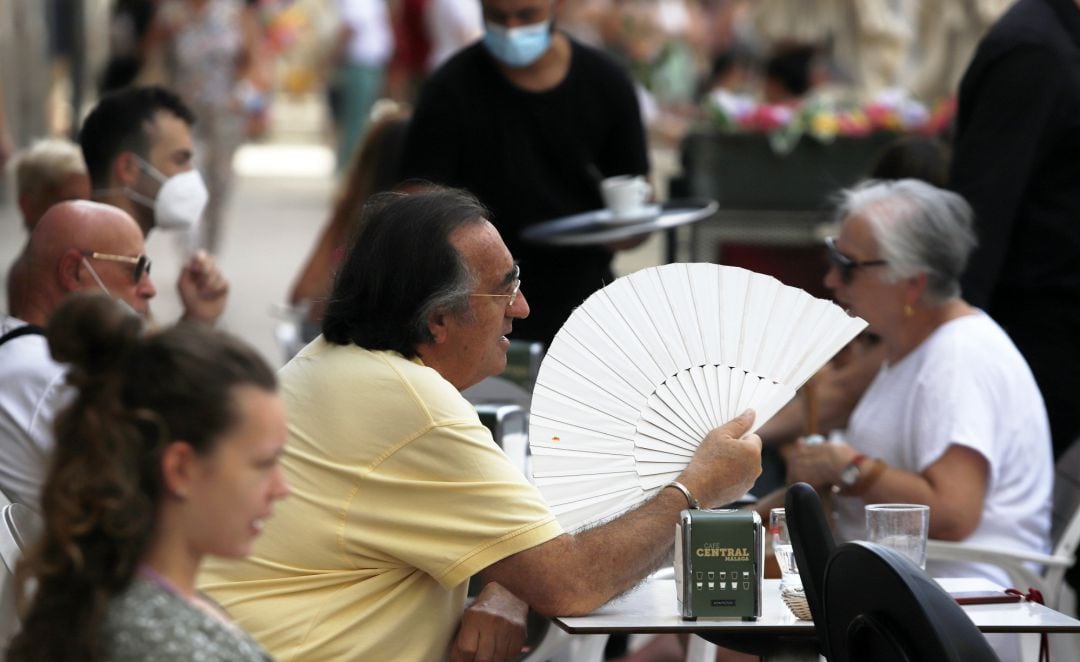 Varias personas intentan protegerse del calor en el día en foto de archivo.