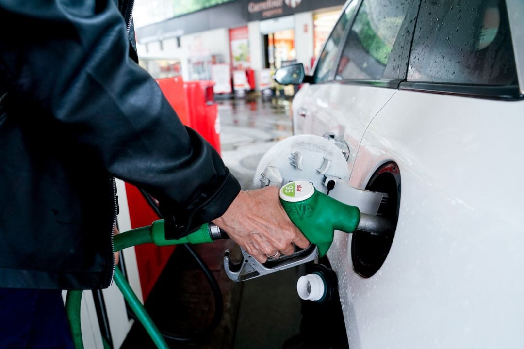 Una mujer pone gasolina a su vehículo en una gasolinera.