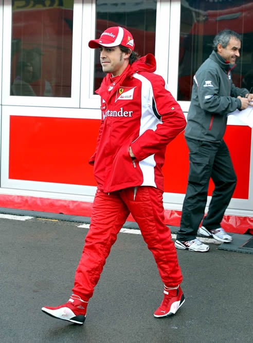 El piloto español de Ferrari, Fernado Alonso, se dirige al box de su equipo antes de inciarse los entrenamientos de pretemporada de Fórmula Uno en el circuito de Cataluña en Montmeló