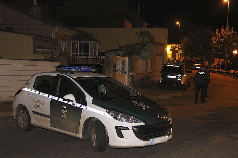 Un coche de la Guardia Civil junto a la vivienda donde aparecieron los cadáveres