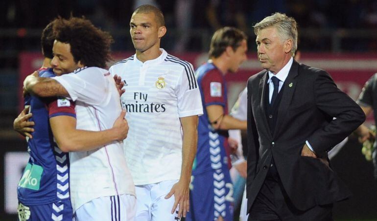 Real Madrid&#039;s Italian coach Carlo Ancelotti (R) leaves the field as his players celebrate their victory at the end of the Spanish league football match SD Eibar vs Real Madrid CF at the Ipurua stadium in Eibar on November 22, 2014. Real Madrid won the match 4-0. AFP PHOTO / RAFA RIVAS