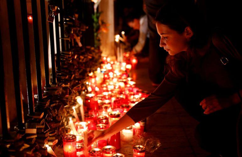 Una mujer deposita una vela en el altar colocado en recuerdo a Daphne Caruana Galizia.