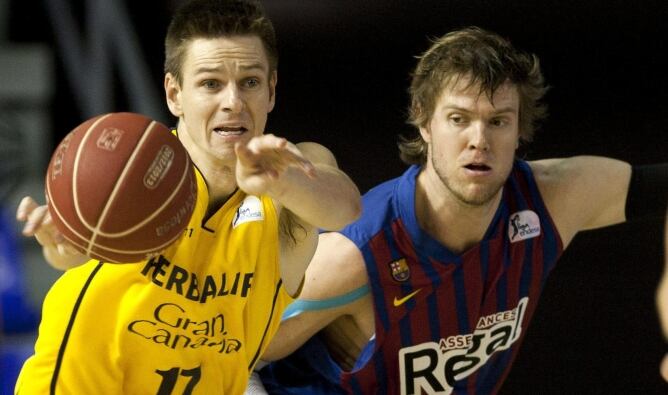 El base madrileño del Herbalife Gran Canaria Tomás Bellas lleva la pelota seguido del ala-pívot estadounidense CJ Wallace, del Barcelona Regal, durante el segundo partido de semifinales de la Liga ACB