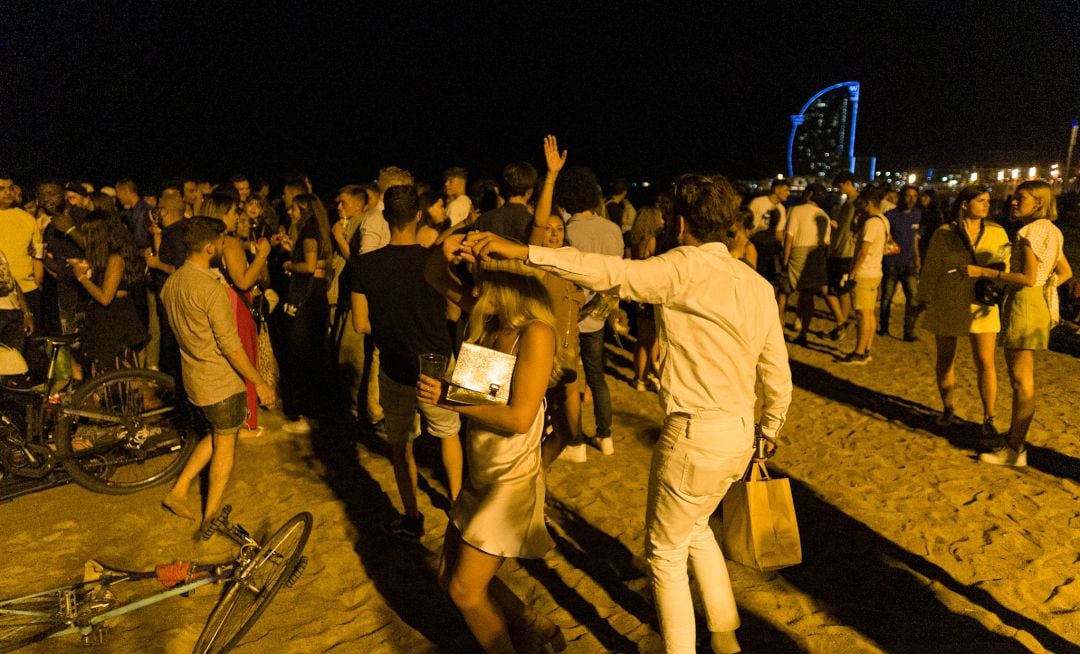 Jóvenes haciendo botellón en la playa de la Barceloneta, en Barcelona.