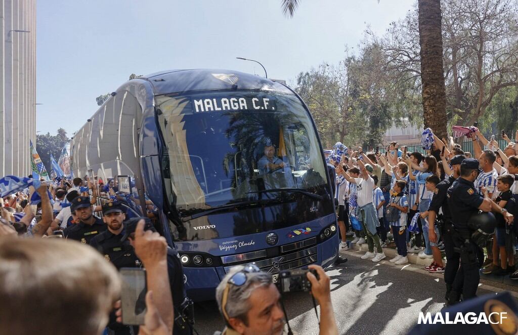 El autobús del Málaga pasa entre los aficionados antes de un partido