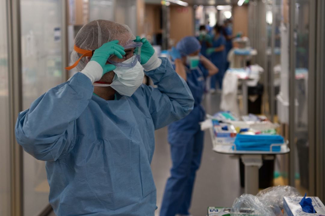 Un profesional sanitario se ajusta las gafas en una UCI