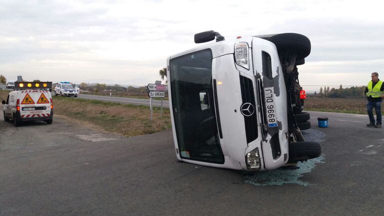 El microbus escolar, volcado en el cruce en el que ha chocado con un turismo