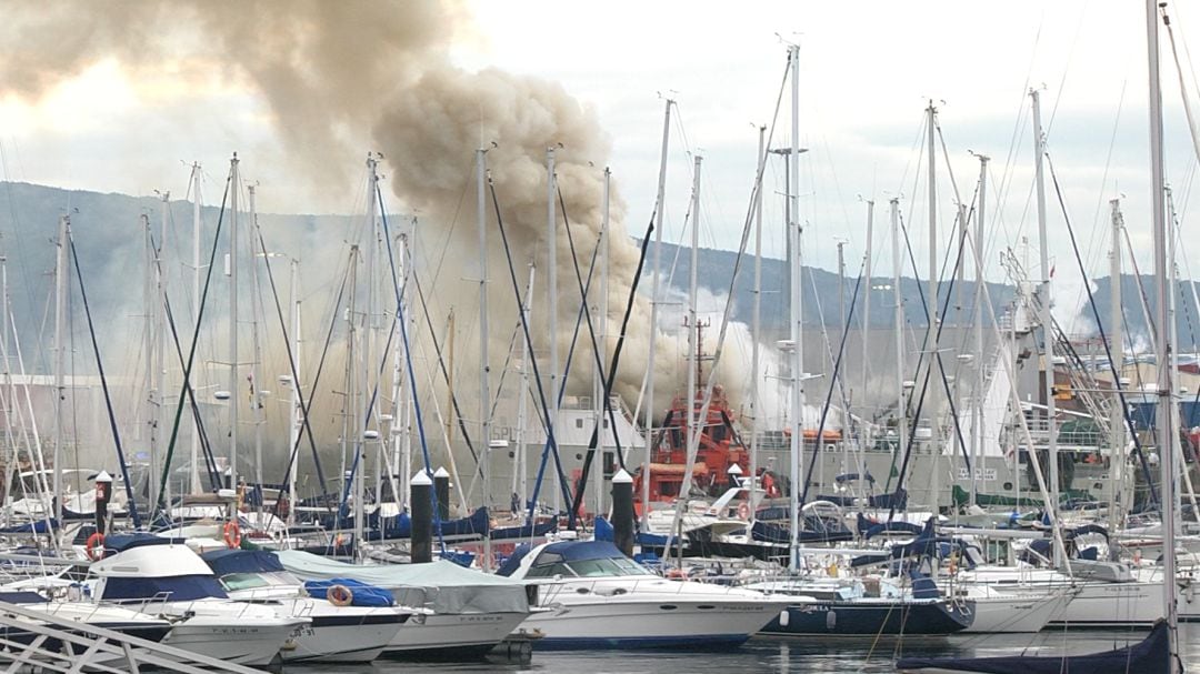 Puerto de Bouzas con el barco ardiendo al fondo