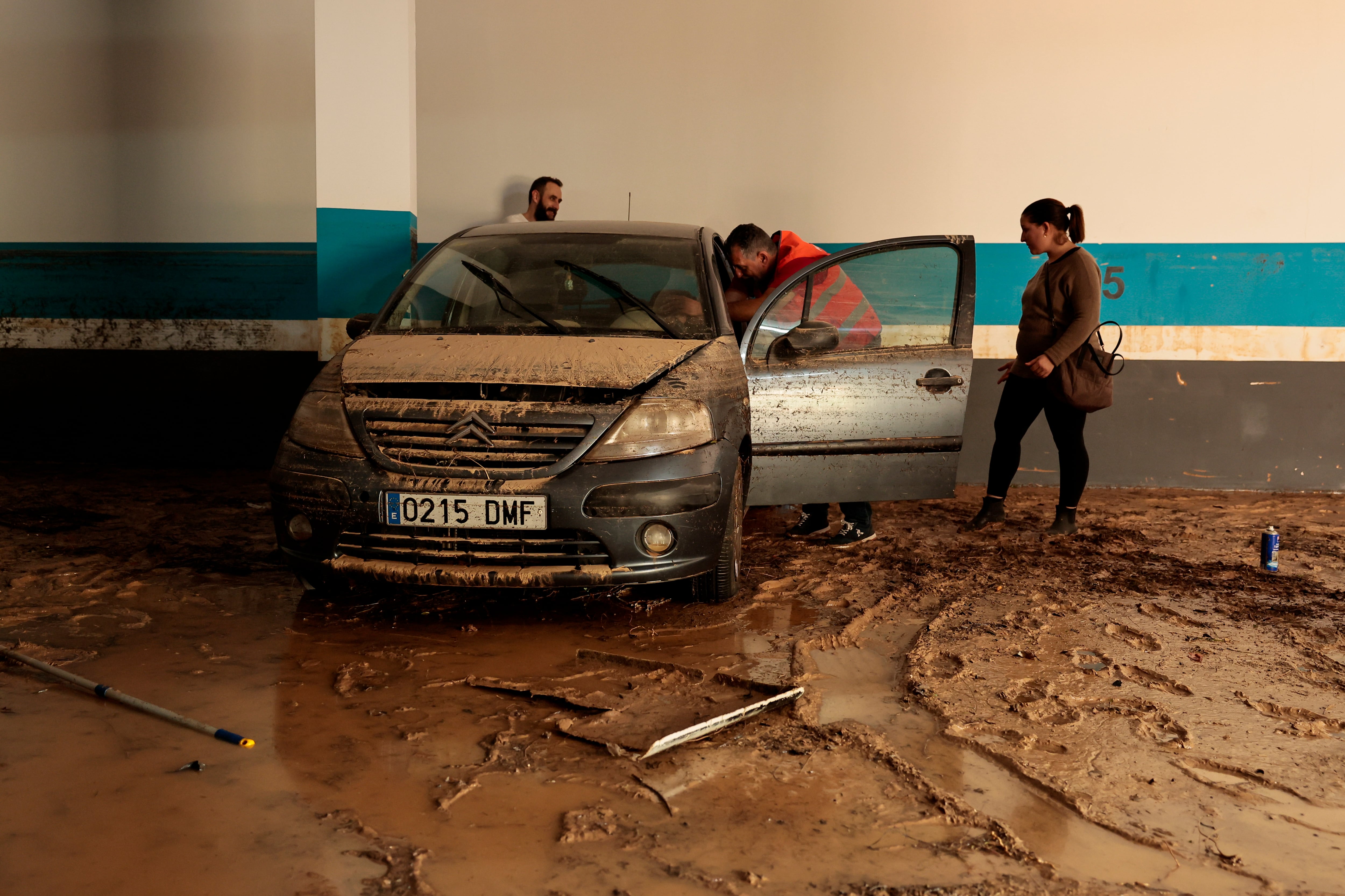 Un mecánico revisa el estado de un vehículo en un garaje que se inundó por las lluvias durante el episodio de DANA del pasado fin de semana en Riba-roja del Turia