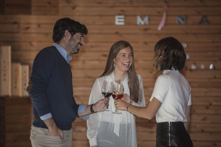 Varios jóvenes brindando con una copa de vino