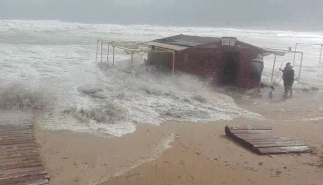 Las olas arrasan un chiringuito en la playa de Daimús. 