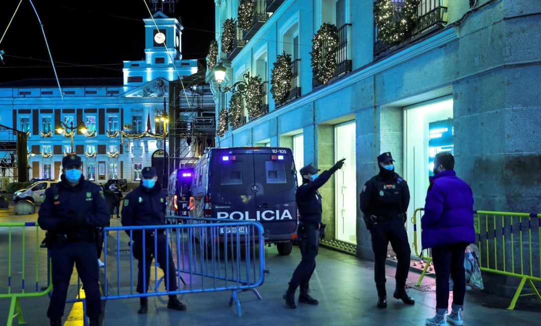 Miembros de la Policía Nacional vigila los accesos a la madrileña Puerta del Sol hoy Miércoles, ante la prohibición de la tradicional celebración que se suceden todos los años en la víspera de las campanadas de Fin de Año.