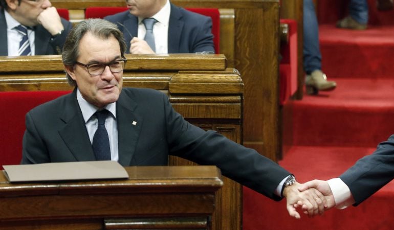 El presidente de la Generalitat en funciones, Artur Mas, da la mano a su conseller de Interior, Jordi Gene.