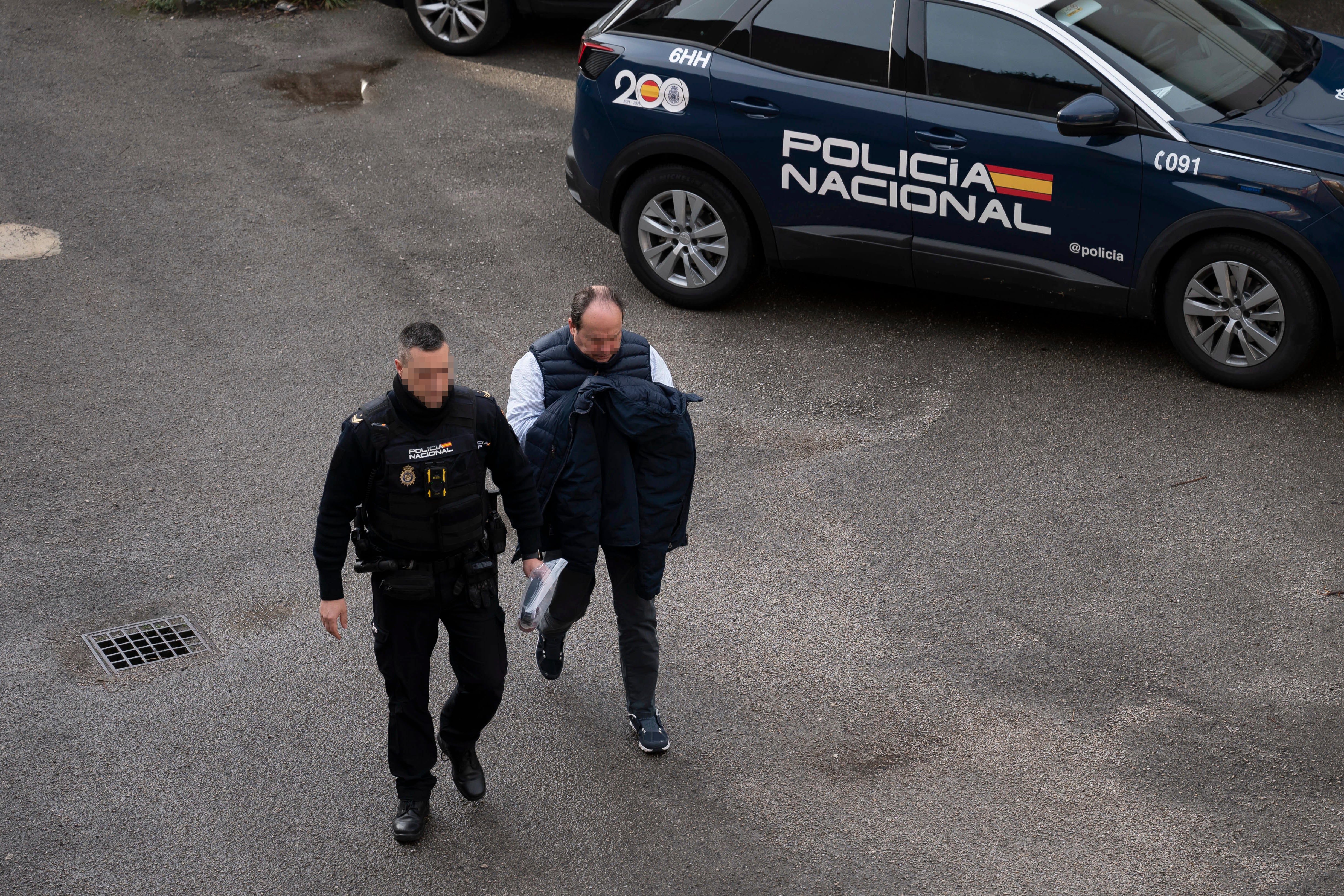 Uno de los detenidos por la presuntas adjudicaciones irregulares en contratos de carreteras de la Consejería de Obras Públicas de Cantabria es escoltado por la policía, este viernes, a su llegada a la Audiencia Provincial de Cantabria en Santander. EFE/Pedro Puente Hoyos