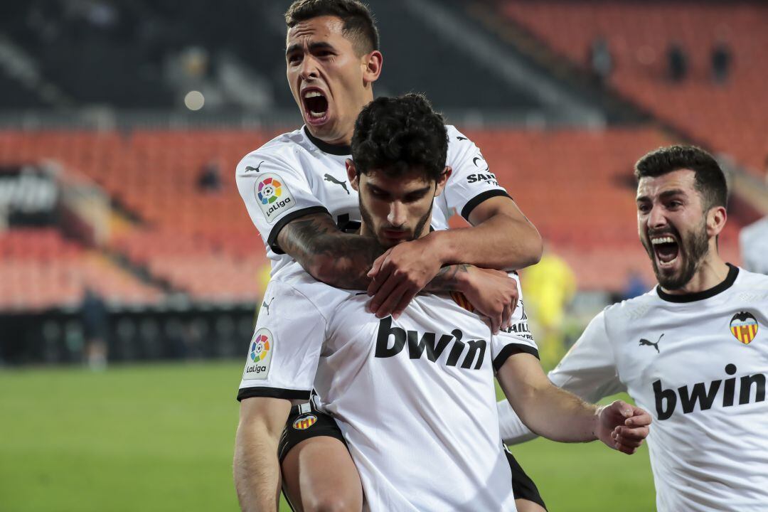 Guedes, Gayà y Oliva celebran un gol con el Valencia