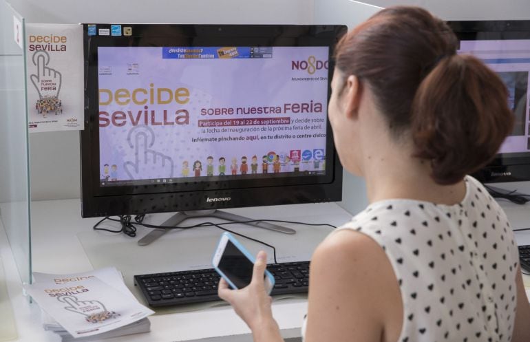 Una empleada del Ayuntamiento de Sevilla ante la web abierta &#039;Decide Sevilla&#039; para votar de forma telemática sobre la fecha de la Feria de Abril, que ha sufrido un colapso en la primeras horas de votación.