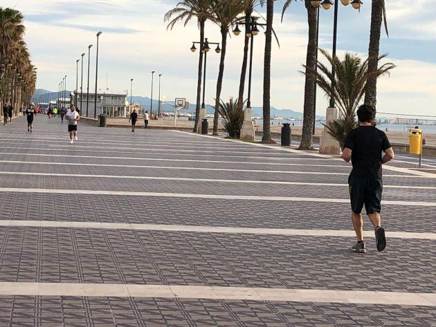 Personas salen a correr por el Paseo Marítimo de València el primer día del establecimiento de horarios para poder salir a la calle tras casi 50 días de confinamiento