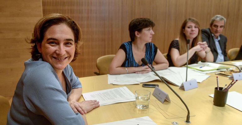 The new mayor of Barcelona Ada Colau (L) poses for photographers as she chairs the first meeting of the government commission at the Barcelona's city hall on June 17, 2015. AFP PHOTO / JOSEP LAGO