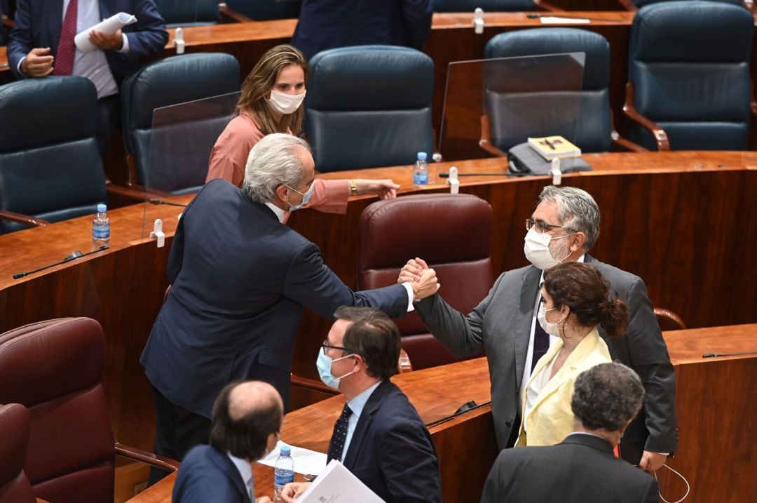 El consejero de Sanidad de la Comunidad de Madrid, Enrique Ruiz Escudero (i), recibe una ovación tras la votación del pleno que la Asamblea este jueves.