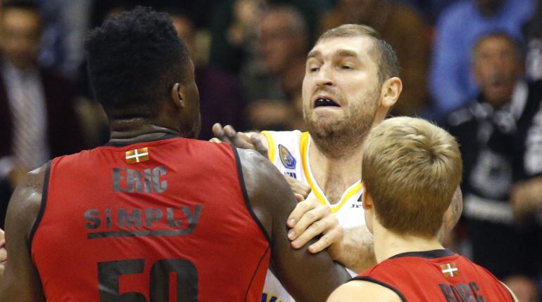 El jugador del Khimki Moscú, Dmitry Sokolov (c) se encara ante el pívot nigeriano Michael Eric (i) del RETAbet Bilbao Basket, durante el partido correspondiente a la tercera jornada del Grupo B de la Eurocup disputado esta tarde en el pabellón de La Casil