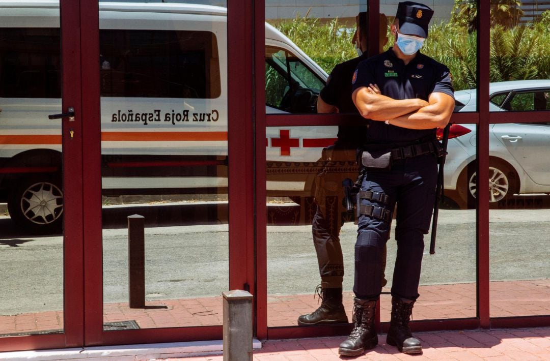 Agentes del Cuerpo Nacional de Policía a las puertas del Centro de Acogida, Emergencia y Derivación de Cruz Roja de Málaga, donde la Consejería de Salud de la Junta de Andalucía ha detectado un foco de coronavirus con más de ochenta personas que han dado positivo.