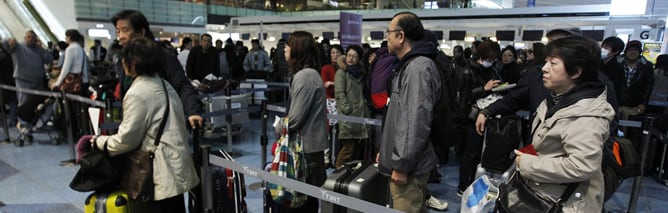 Varios pasajeros guardan cola en el aeropuerto de Haneda, en Tokio