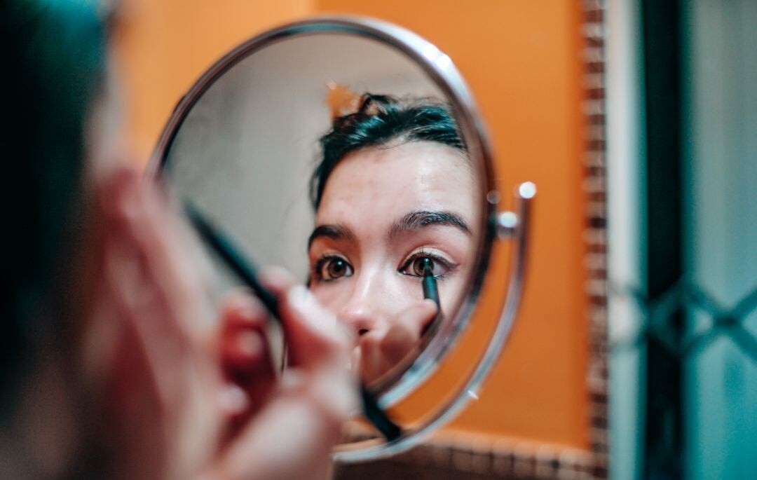 Una mujer aplicándose un eyeliner