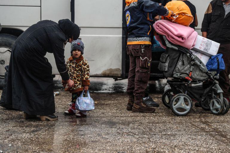 Personas que fueron desplazadas por la fuerza de las ciudades al sur de Damasco llegan  al cruce de Qal'aat al-Madiq en el campo norteño de Hama (Siria). 